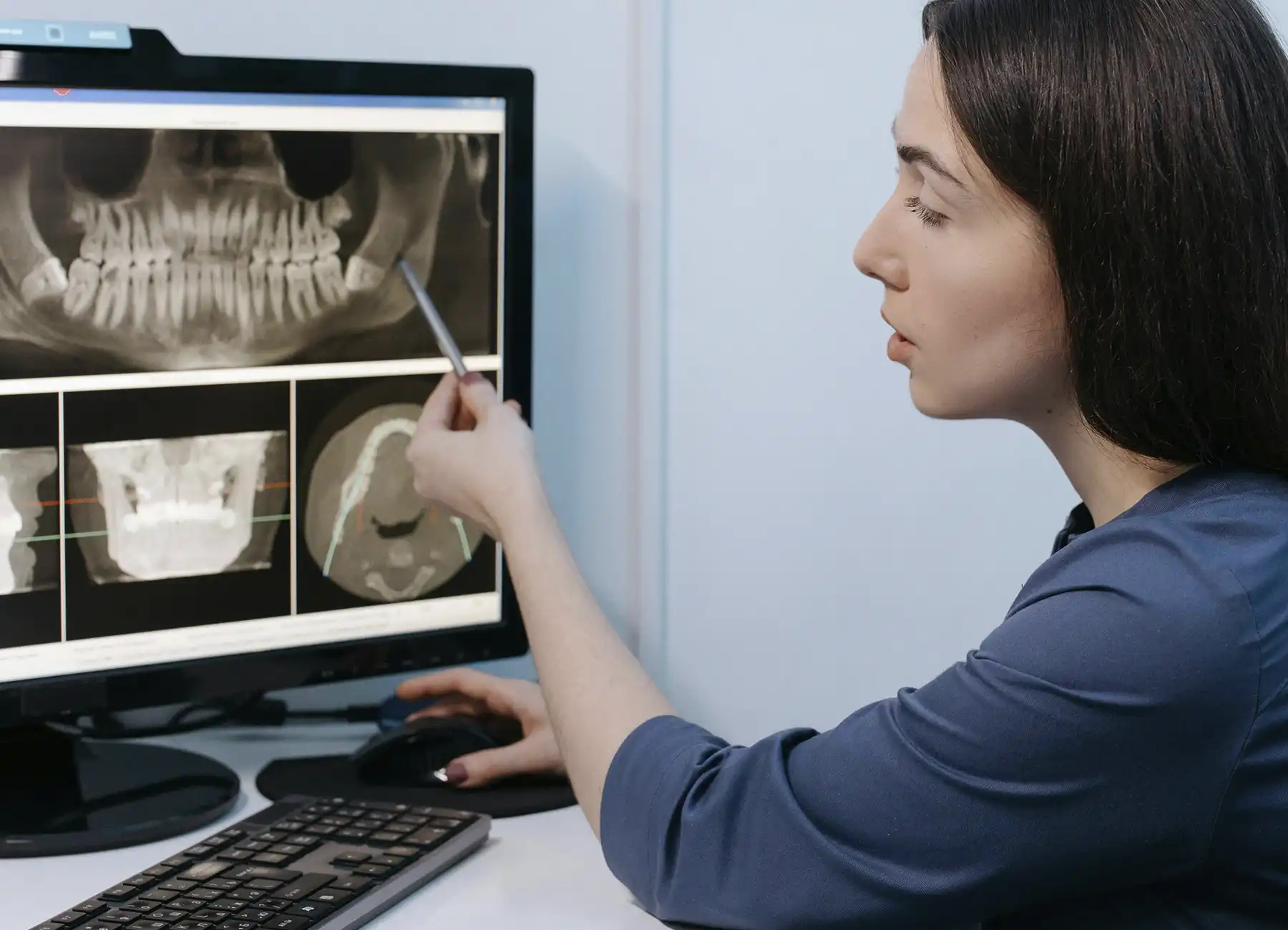 Doctor explicando a paciente opciones de brackets para dientes montados en consulta